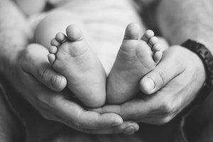 Closeup Shot Of A Baby's Feet Held In His Father's Hands